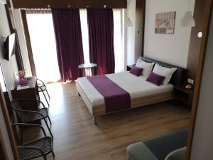 北马马亚-讷沃达里Dream Resort (Adults only 14+)的一间卧室配有一张带紫色枕头的大床