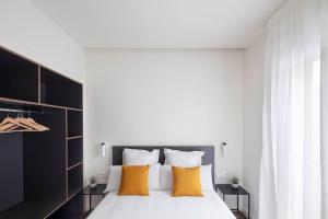 洛格罗尼奥Invino Apartments的一间卧室配有一张带黄色枕头的大床