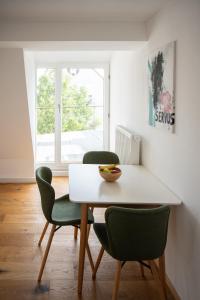 布鲁赫萨尔Anni`s Inn的一间设有白色桌子和绿色椅子的用餐室