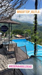 希利特拉ROOF TOP Hotel XILITLA的一个带游泳池和桌椅的度假村