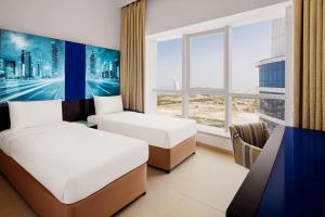 迪拜阿大吉奥高级迪拜阿尔巴沙公寓式酒店的酒店客房设有两张床和窗户。