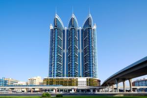 迪拜阿大吉奥高级迪拜阿尔巴沙公寓式酒店的一座有三座高耸摩天大楼的大建筑