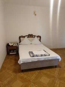 塞凡Hayots Ojakh的一间卧室配有带白色床单和枕头的床。