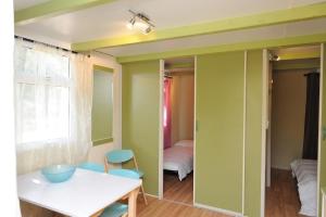 维琪奥港CAMPING LES ILOTS D'OR的一间拥有绿色墙壁和桌椅的用餐室