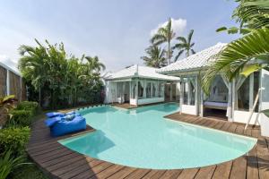 塞米亚克Villa Laksmana Hideaway 2 - Surrounded by water- 2bd villa with fantastic pool!的一个带木甲板和房子的游泳池