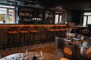 杜柏Hotel & Restaurant Maison Pal'Ange的餐厅内带木凳的酒吧