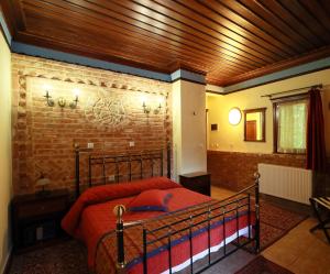 斯塔夫鲁波利涅墨西斯酒店的一间卧室设有一张床和砖墙