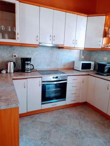 圣尼古拉奥斯Niki House的厨房配有白色橱柜和炉灶烤箱。