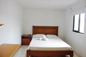 马尼萨莱斯El Cable Hostal的一间小卧室,配有一张床和一张桌子
