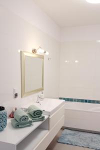 格但斯克Apartament Seventh Heaven的浴室配有盥洗盆、镜子和浴缸