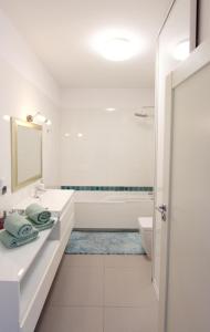 格但斯克Apartament Seventh Heaven的白色的浴室设有浴缸和水槽。
