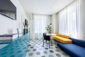 卢卡Villa Fedora Luxury Suites的客厅配有黄色的沙发和桌子