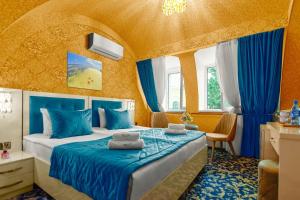 巴库Center Hotel Baku的一间卧室配有一张带蓝色床单和蓝色窗帘的床。