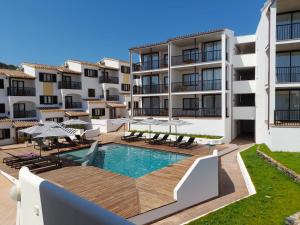 马翁Calallonga Hotel Menorca的公寓设有游泳池和庭院家具。