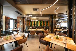 阿拉德Aniroc Signature Hotel的用餐室配有木桌和椅子