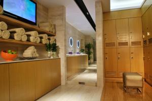 深圳深圳皇庭V酒店的走廊设有木制橱柜、电视和椅子