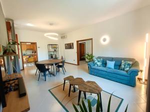 里米尼Residenza Palmina的客厅配有蓝色的沙发和桌子