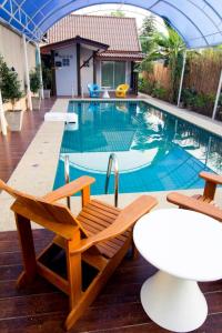 素可泰Pai Sukhothai Resort SHA Extra Plus的一个带两把椅子和一张桌子的游泳池