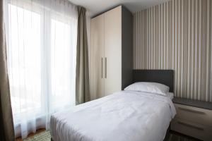 萨拉热窝Green Nature Hotel & Apartments的一间卧室设有一张床和一个大窗户