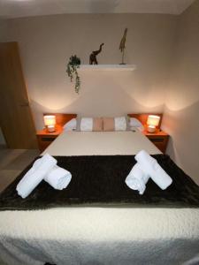 马拉加Robles home的一间卧室配有一张带毛巾和两盏灯的床。