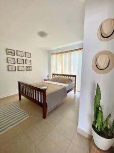 CocléModerna casa con piscina a 10 min de la playa的一间卧室配有一张床和盆栽植物