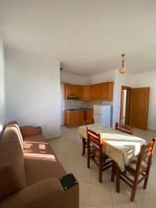 都拉斯"Adriatik Hills" Apartments COMPLEX的厨房以及带桌子和沙发的用餐室。