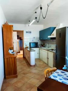 马里迪莫Marettimo la casa sulla spiaggia的厨房配有蓝色橱柜和桌子