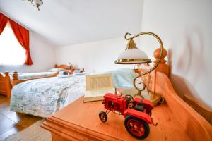 伊利尔斯卡比斯特里察Farm Stay Peternelj的一张桌子上床边的红色玩具拖拉机