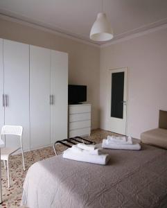 卡塔尼亚Giuffrida Apartment Rooms的一间卧室配有一张床、一把椅子和电视