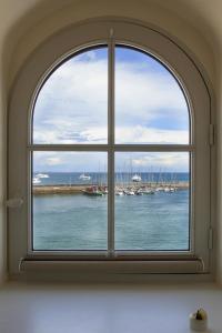 勒帕莱Les Appartements d'Alexandre的享有海港景色的拱形窗户