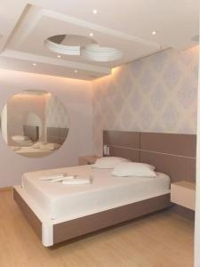 拉热斯Motel Chevalier的卧室配有白色的床和圆形镜子