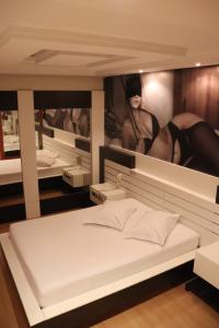 拉热斯Motel Chevalier的一间卧室,配有一张带女性海报的床