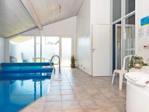 森讷比10 person holiday home in Juelsminde的一间带游泳池和浴缸的浴室