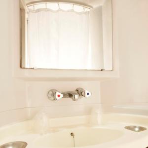 拉克雷奇东尼奥尔普托儿所瑞米尔经典酒店的白色的浴室设有水槽和窗户。