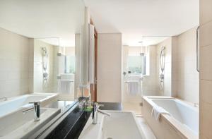 青岛青岛中心假日酒店（五四广场）的浴室配有两个盥洗盆和浴缸。