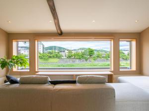 京都京都白鹭度假屋的一间带沙发和大窗户的卧室