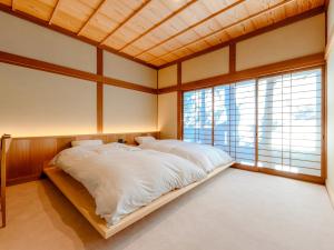 别府Kappo Ryokan Yumesaki的一间带一张大床的卧室,位于带窗户的房间内