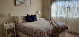 莱克斯恩特伦斯Abalone Guest Accommodation的一间卧室设有一张床和一个大窗户