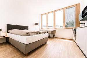 因斯布鲁克LOOMZ living Self-check-in的卧室配有一张床、一张书桌和窗户。