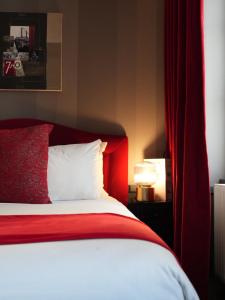 里昂亚历山德拉酒店的一间卧室配有红色的床和红色窗帘