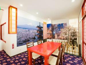 那霸沖縄の宿 行燈 あんどん的一间用餐室,配有红色桌子和山壁画