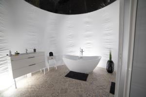 诺茨瓦约Nomad Hotel & Glamping的白色的浴室设有浴缸和水槽。