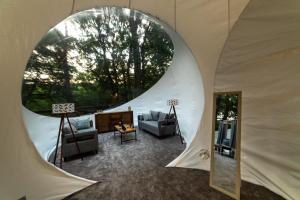 诺茨瓦约Nomad Hotel & Glamping的帐篷内的客厅,设有圆形窗户