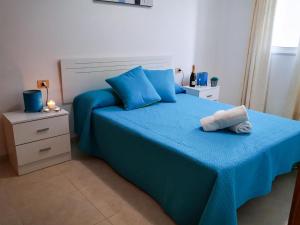 圣胡安海滩Puesta de Sol Rentals 3AR的一间卧室配有蓝色的床和蓝色枕头