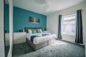达灵顿Barron House By Horizon Stays的一间卧室配有一张蓝色墙壁的床和一扇窗户