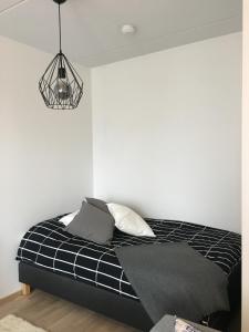 伦派莱MODERNI YKSIÖ HUIPPUSIJAINNILLA!的卧室配有黑白床和灯