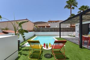 拉普拉亚蒂陶洛Tauro Serenity by VillaGranCanaria的一个带游泳池和两把椅子的小后院