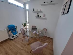 希欧福克Lily Apartman Siófok的一间设有玻璃桌和椅子的用餐室