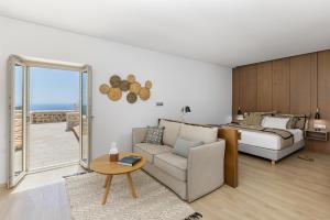 阿里奥波利斯Salvia Areopolis All Suite Hotel的一间卧室配有一张床、一张沙发和一张桌子
