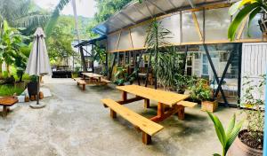 昆岛Hotel De Condor的一个带野餐桌和遮阳伞的庭院